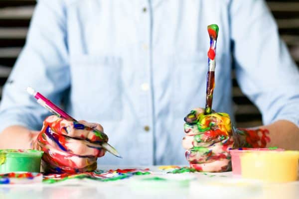 Man holds painted mess with click pen and brush