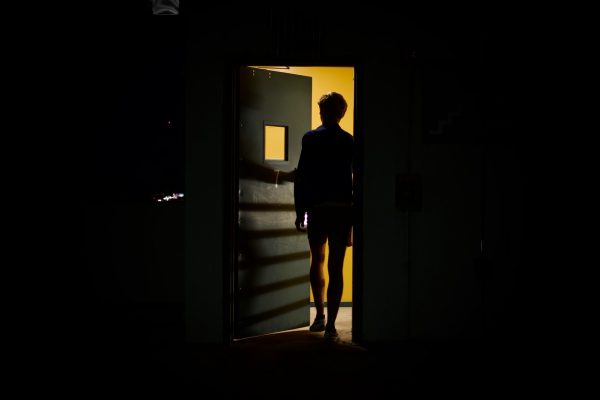 Silhouette of a person walking through a door