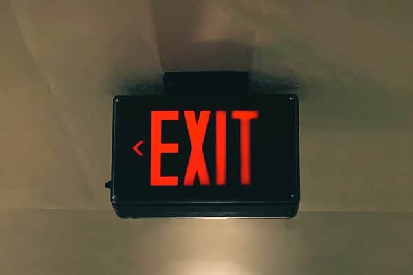 A red exit sign hanging from the ceiling