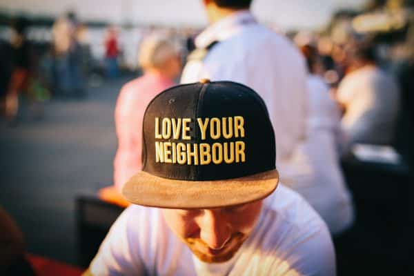 Person wearing Love Your Neighbour cap