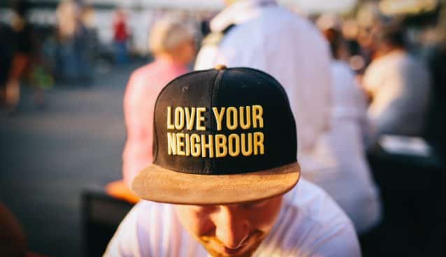 Person wearing Love Your Neighbour cap