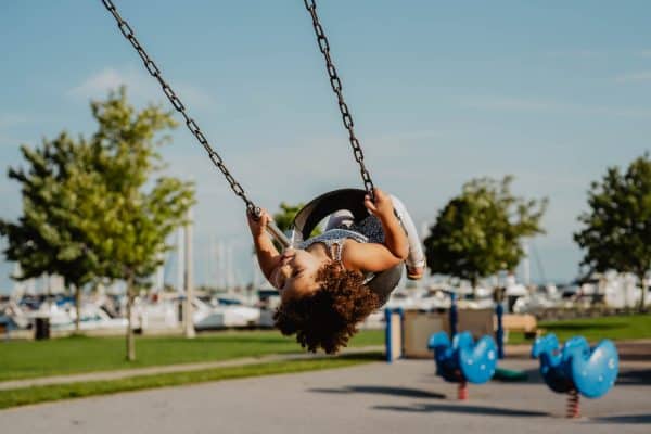 Toddler swinging at the harbor near Burlington, Ontario
