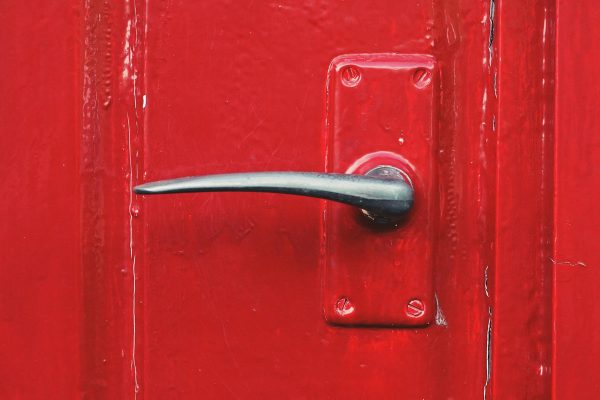 Metal door handle on a red door