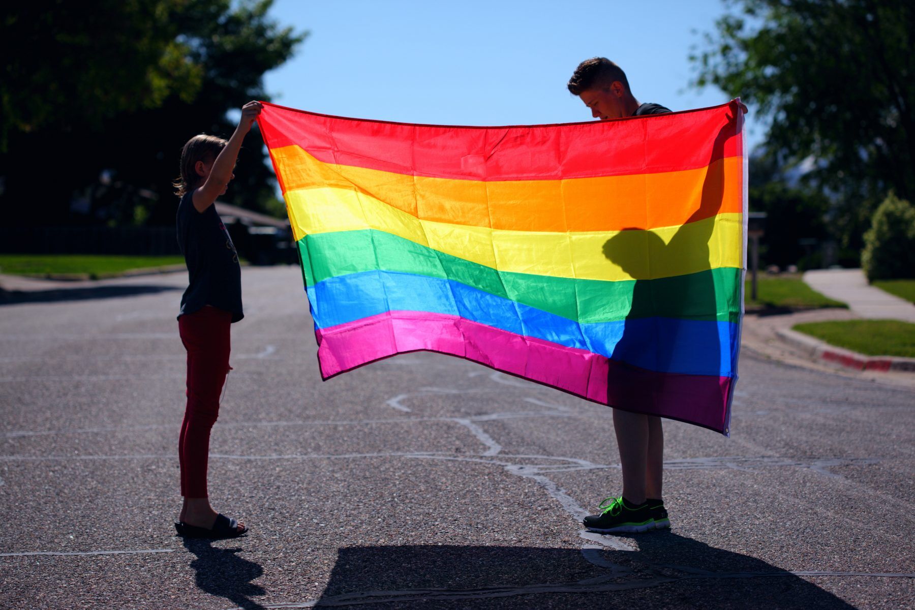 Two people holding Pride flag