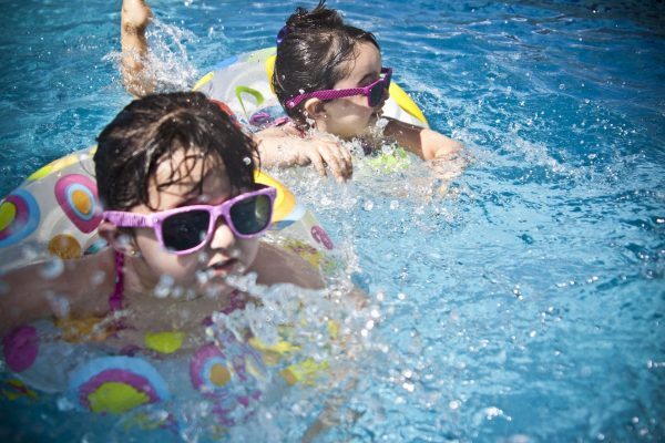 Girls swimming in pool wearing sunglasses